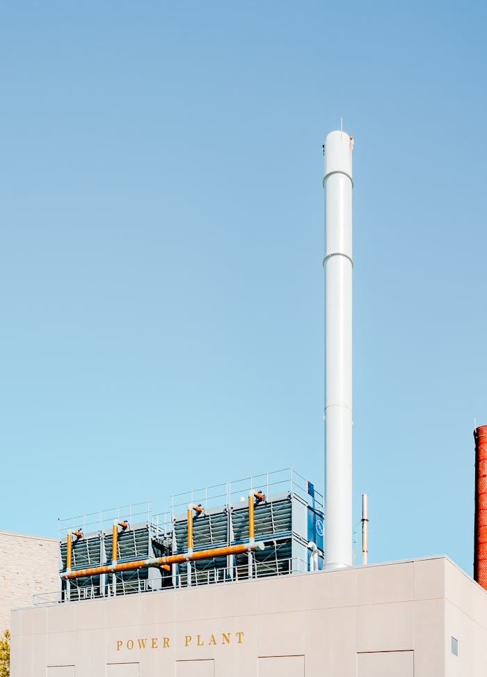 Home Modern industrial power plant with smokestacks under clear blue sky.